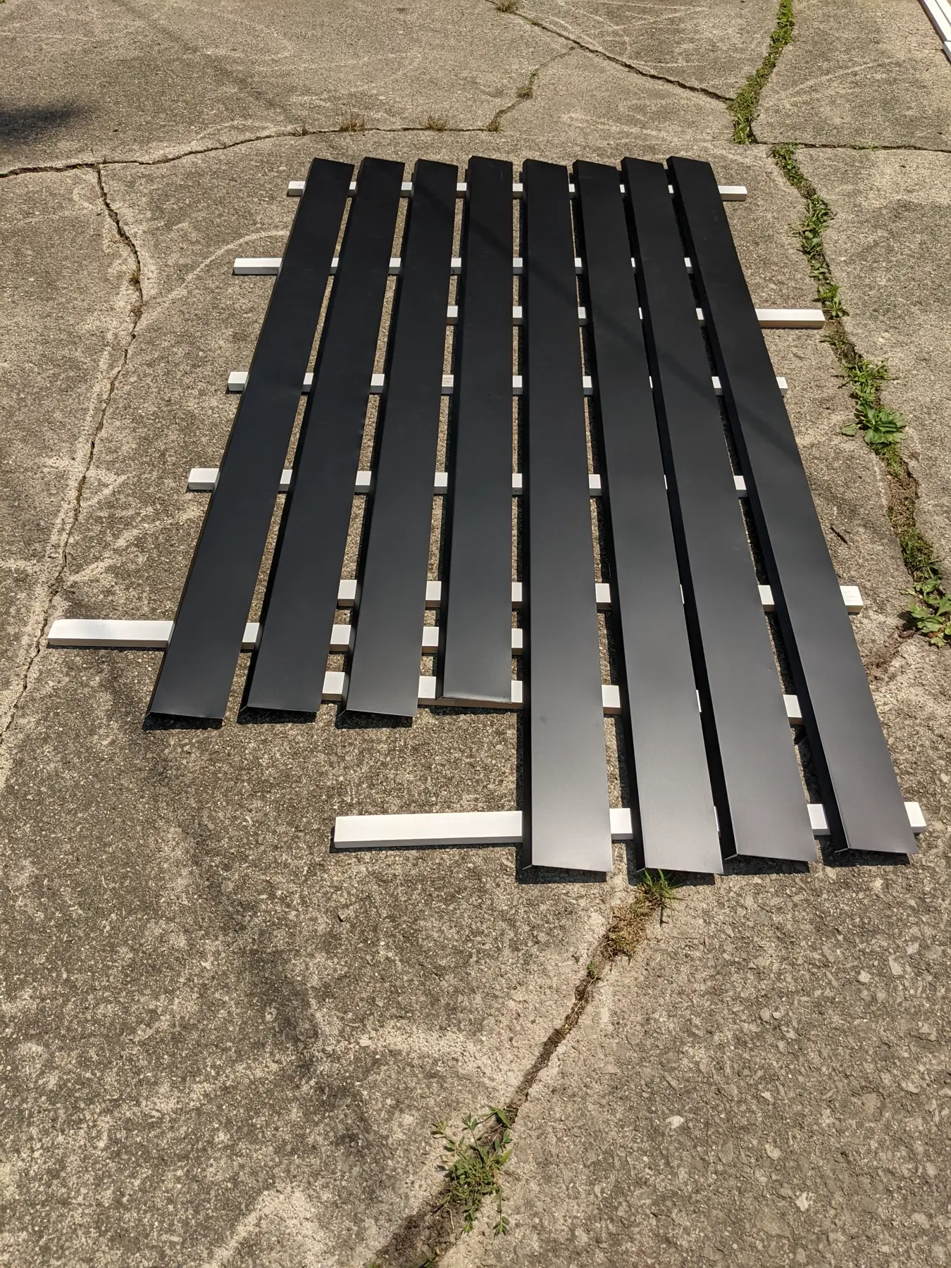 Long black aluminum-coil strips prepared for bending.
