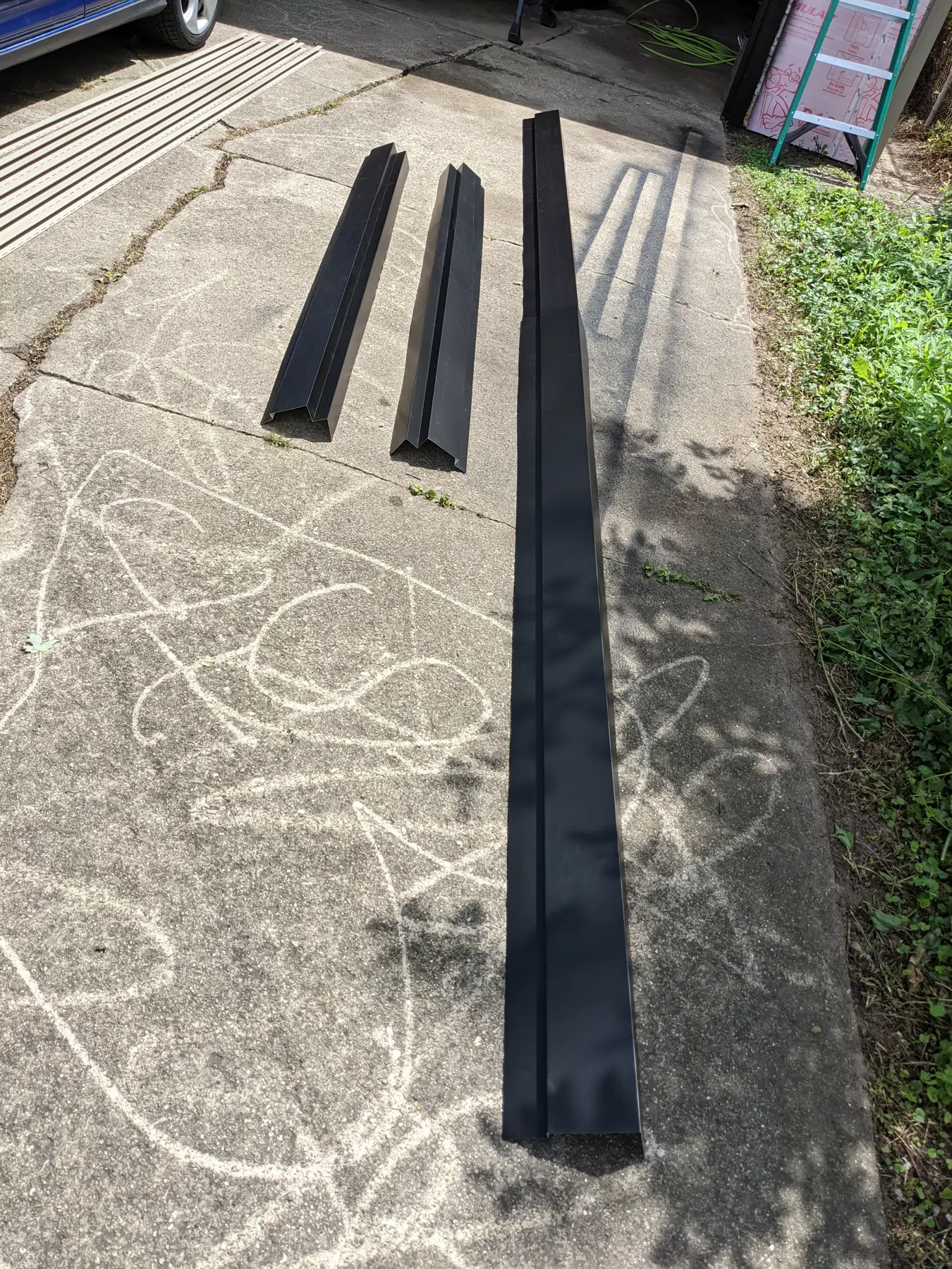 Three long aluminum flashing sections after bending.