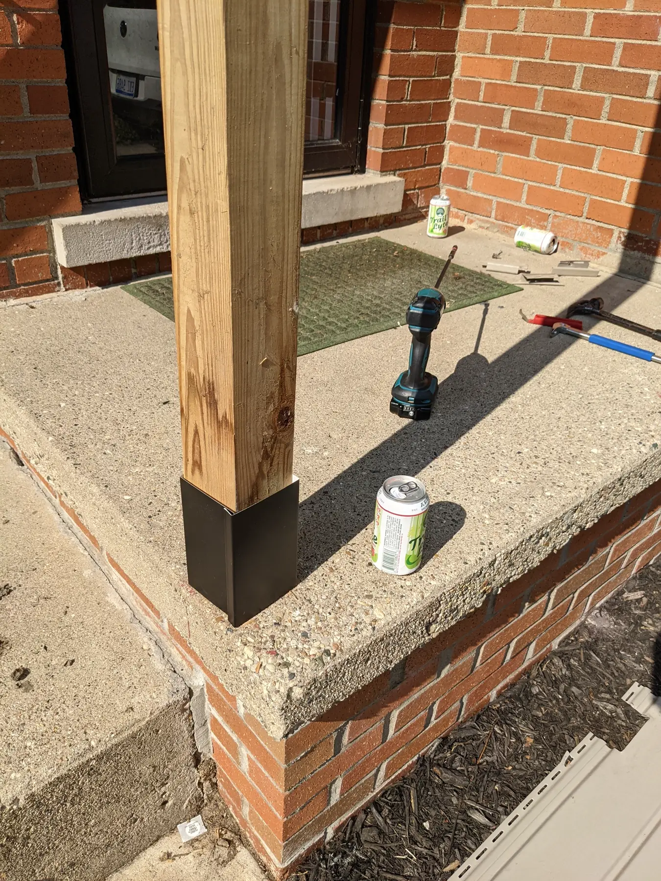 Custom aluminum wrap being installed at the base of the entrance post.