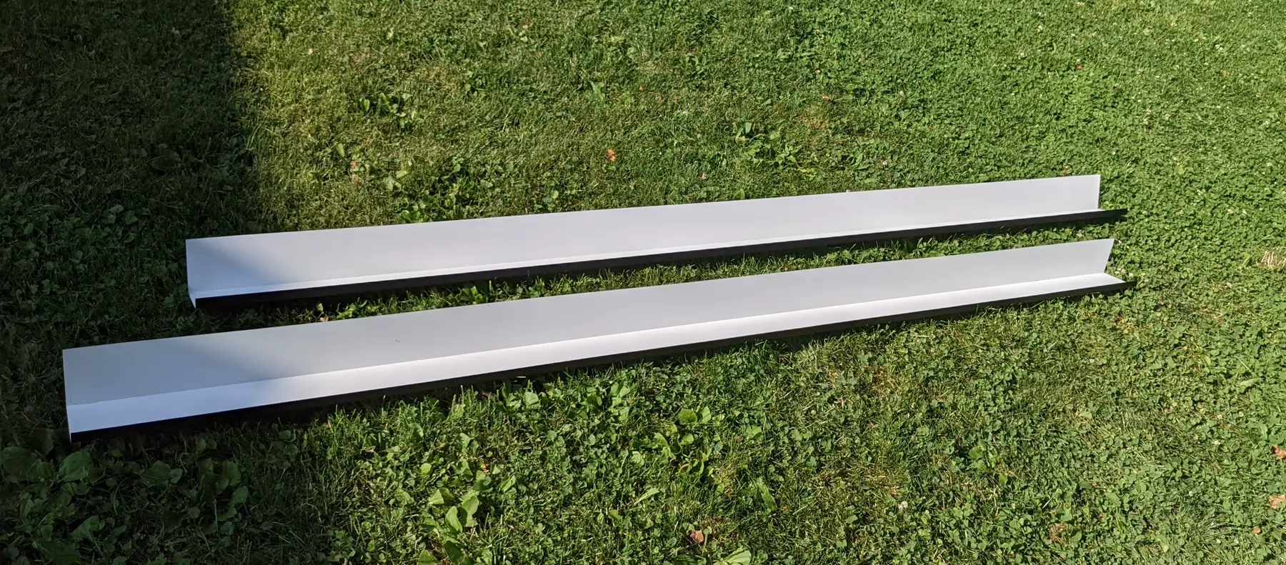 Two light-colored aluminum channel profiles placed side by side.