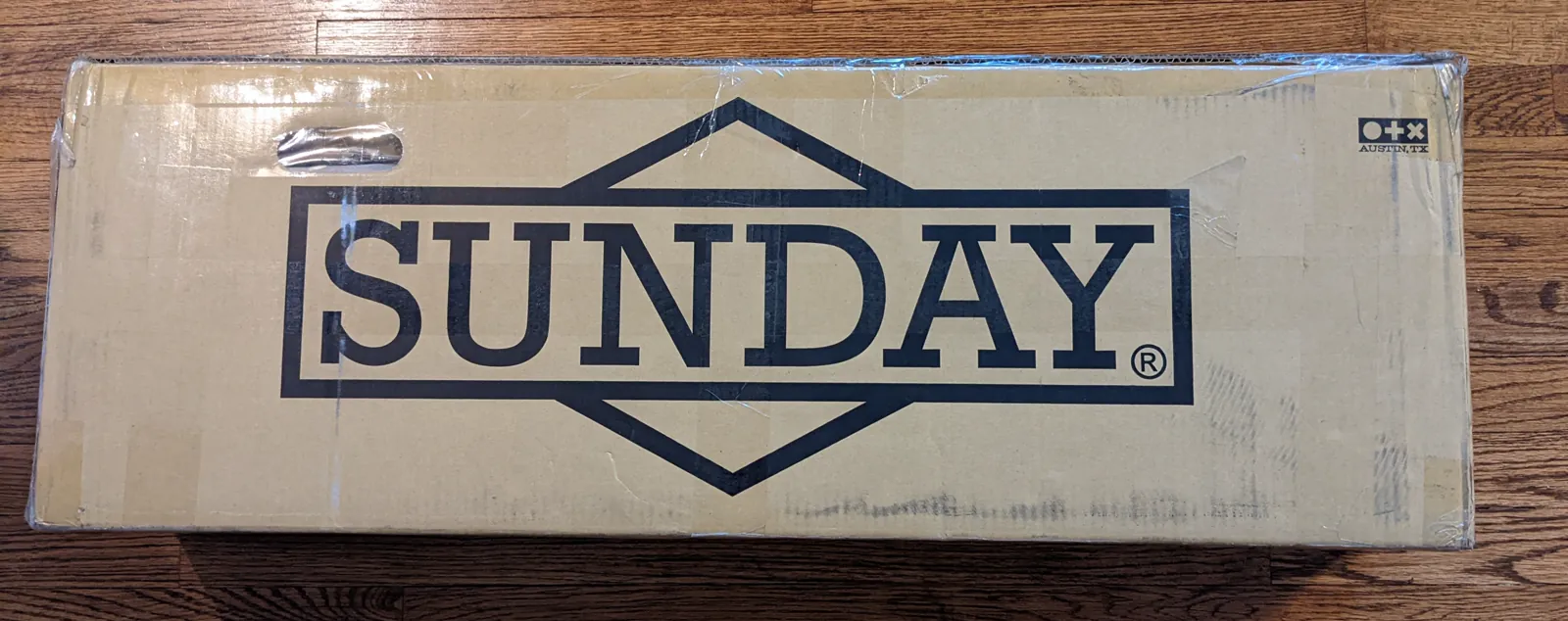 Large Sunday-branded frame box on a wood floor.