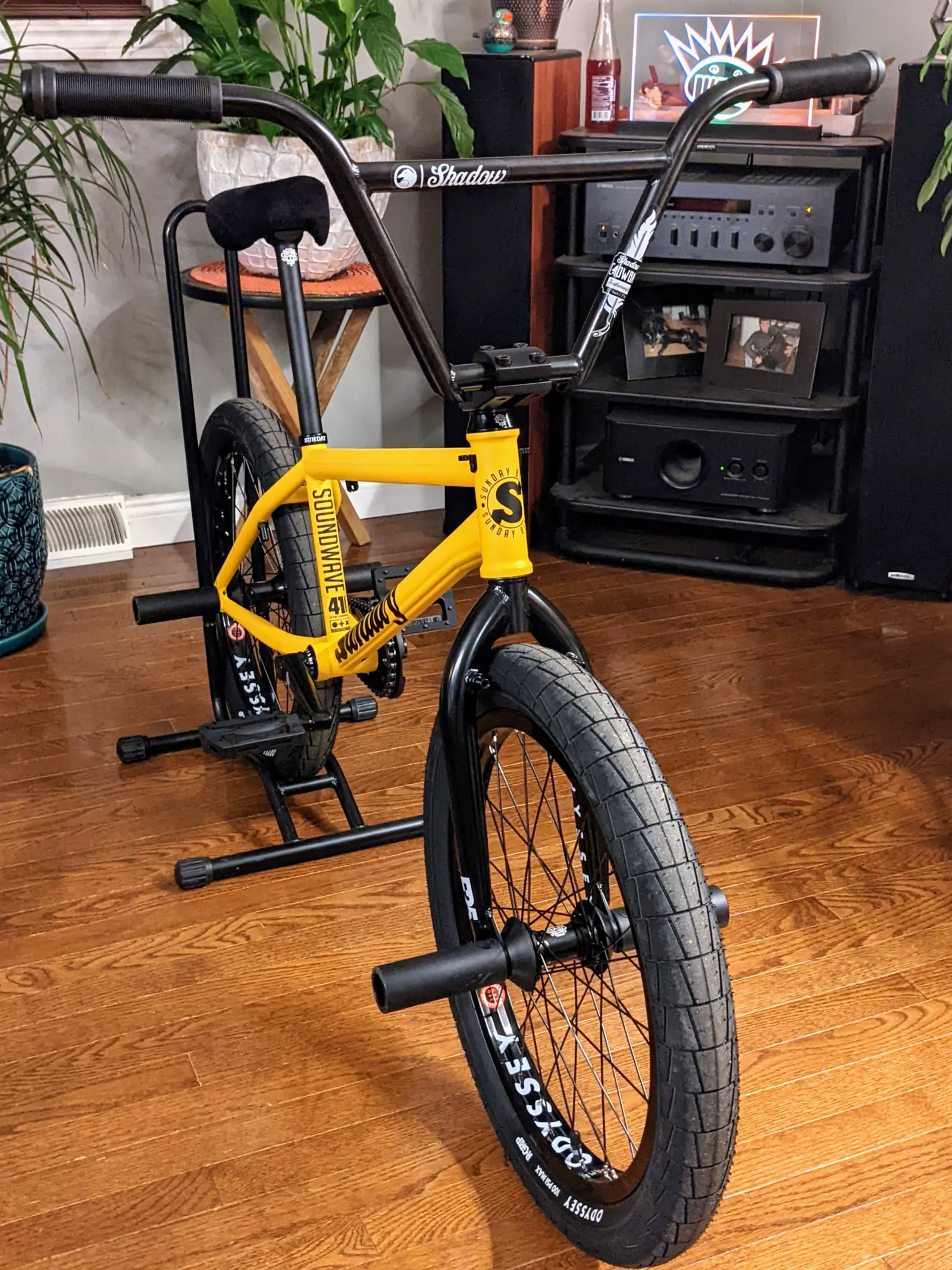Front three-quarter view of the newly assembled yellow Sunday Soundwave on a work stand indoors.