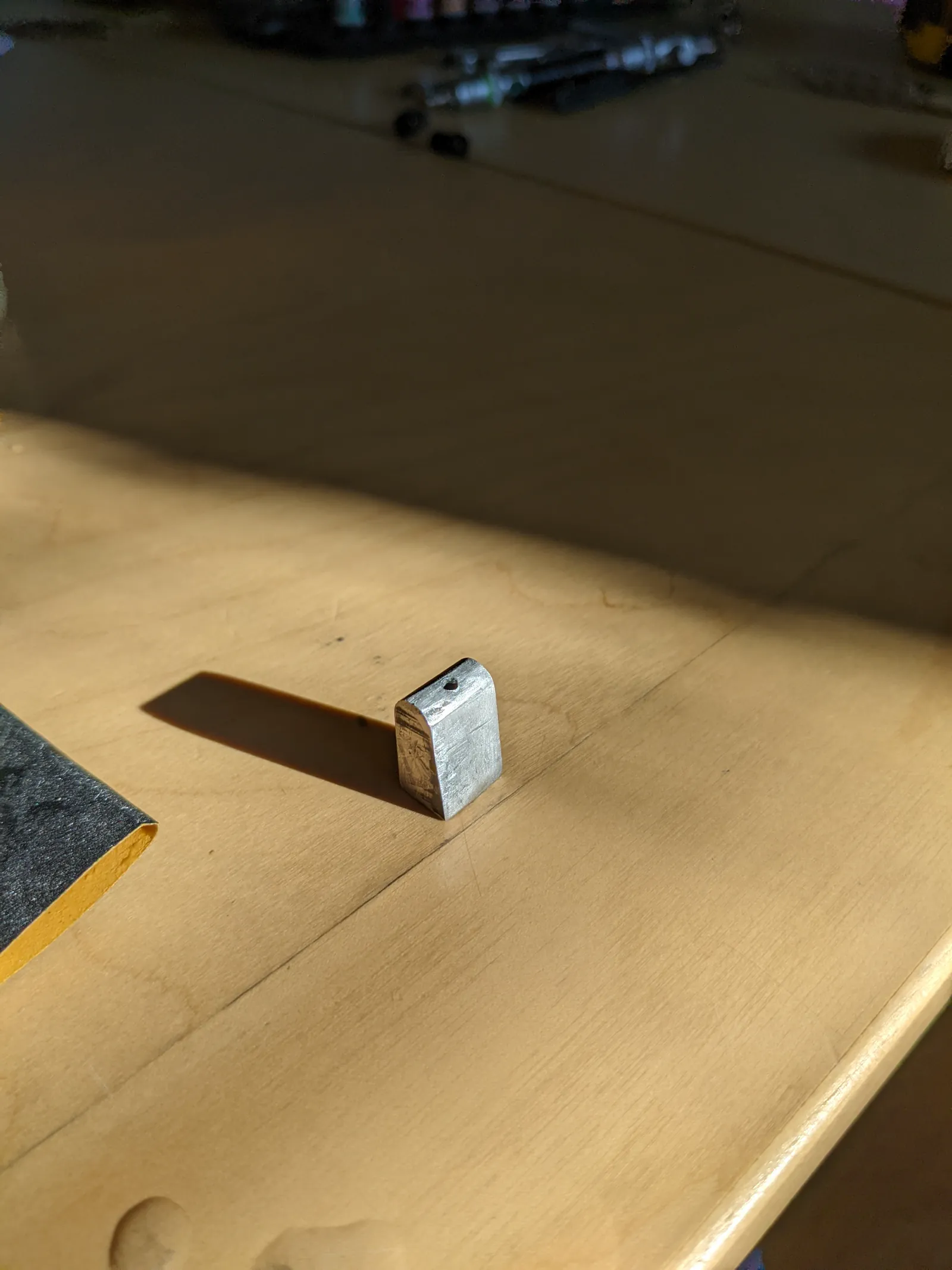 Small metal part standing on masking paper before spray finishing.