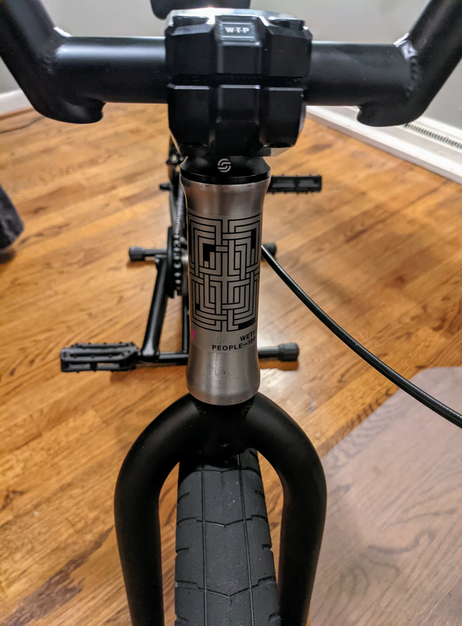 Centered view of the WTP stem, raw headtube, black fork, and front tire.