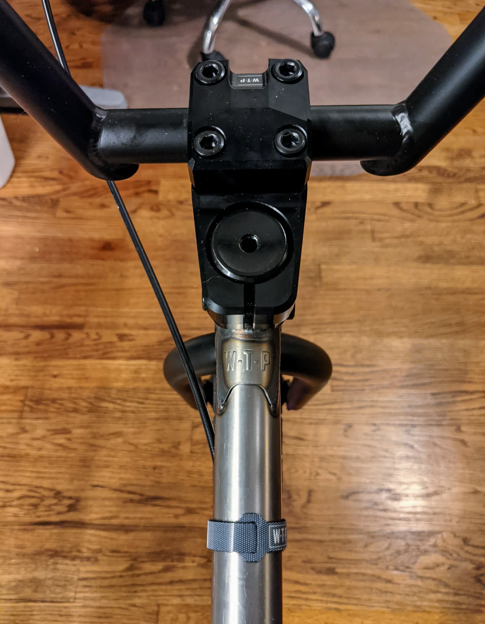 Close top-down view of the black stem centered over the raw top tube.