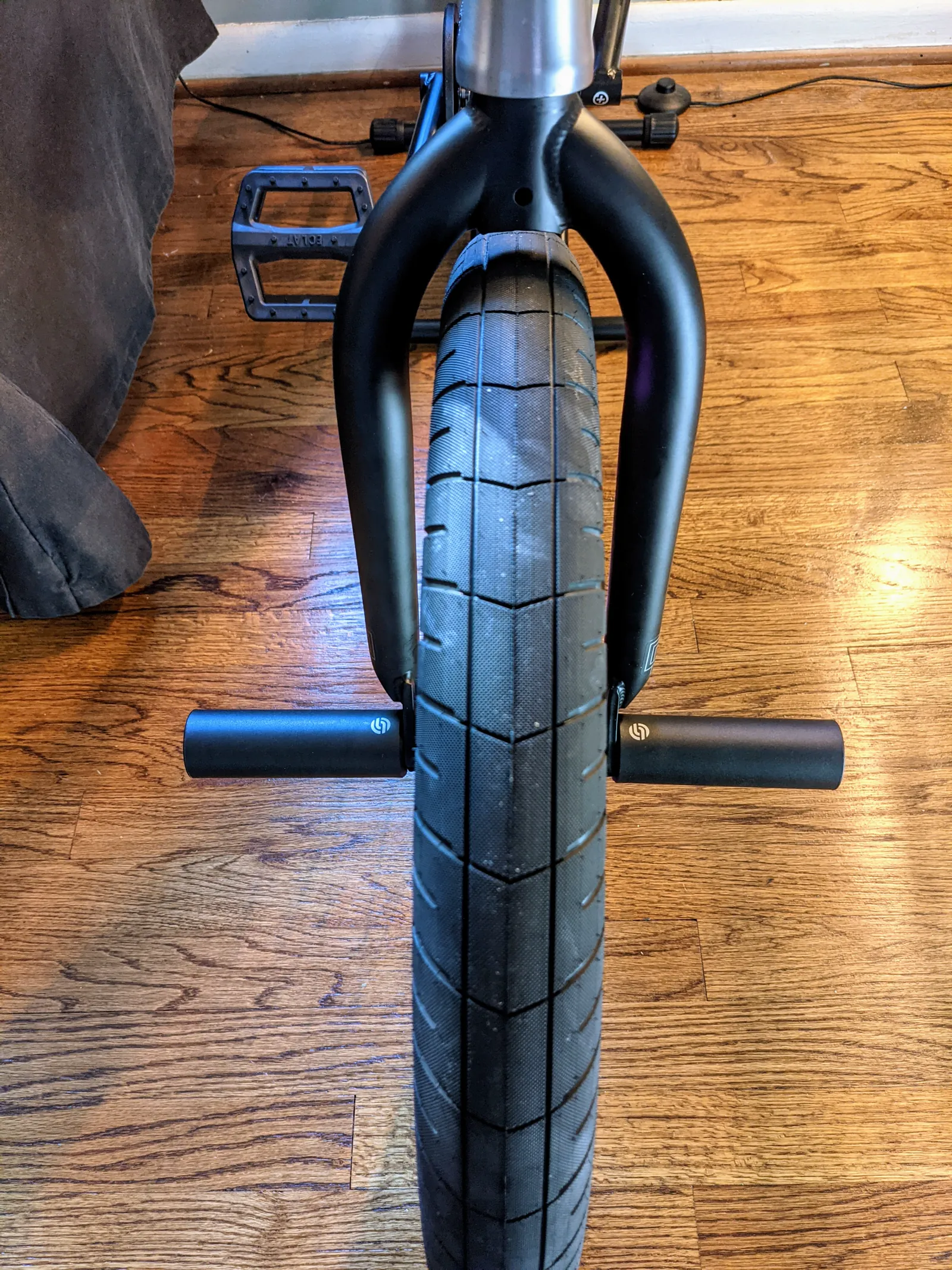 Centered view of the black fork, wide front tire, and front pegs.