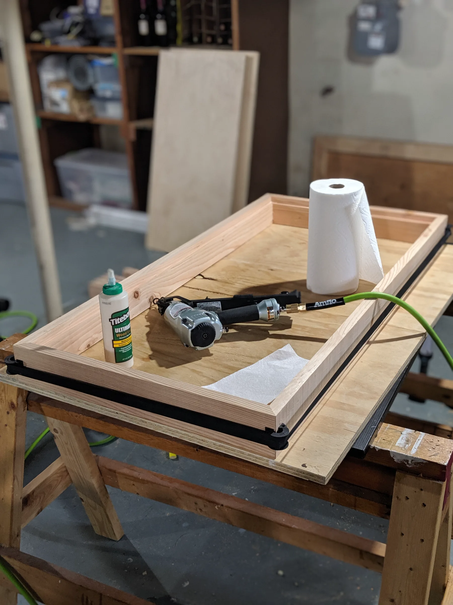A rectangular fir frame clamped around a birch panel on a workshop table.
