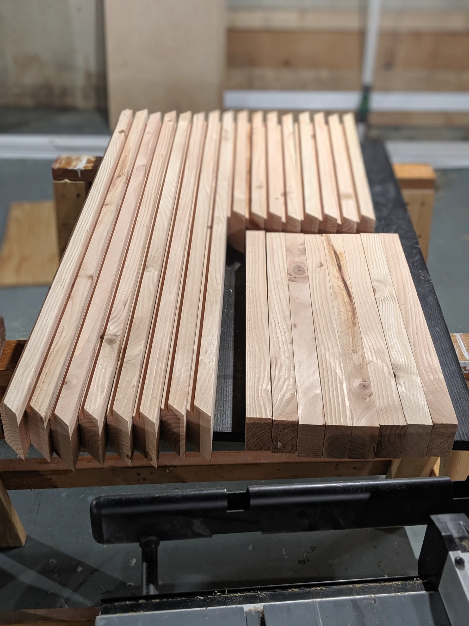 Prepared long frame rails and shorter cross pieces organized on a workbench.