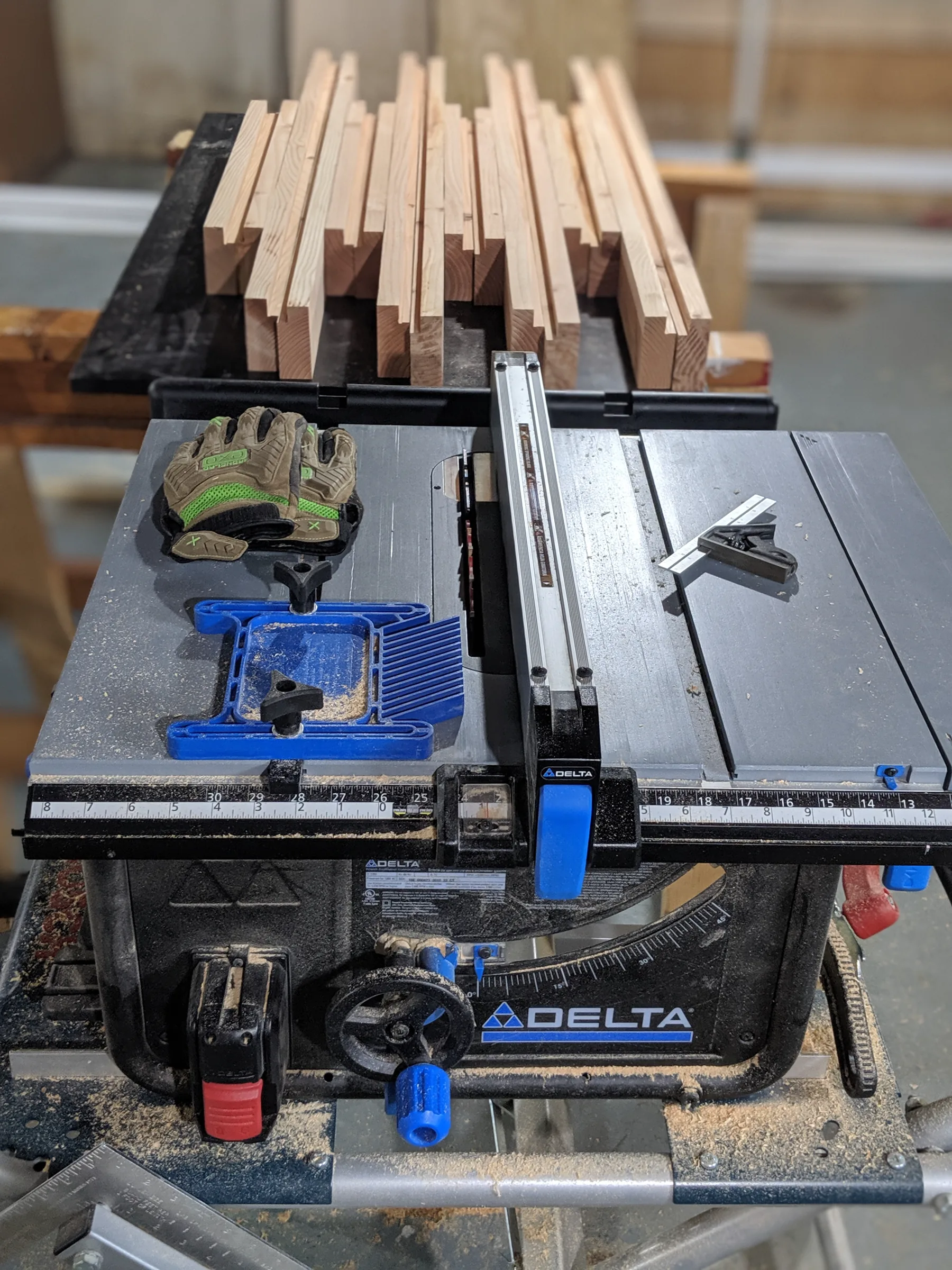 Narrow fir frame pieces arranged across a table saw after milling.