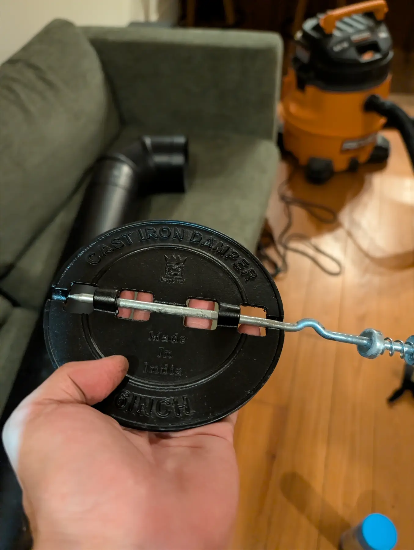 Round pipe-damper plate, shaft, spring handle, and related hardware during fitting.