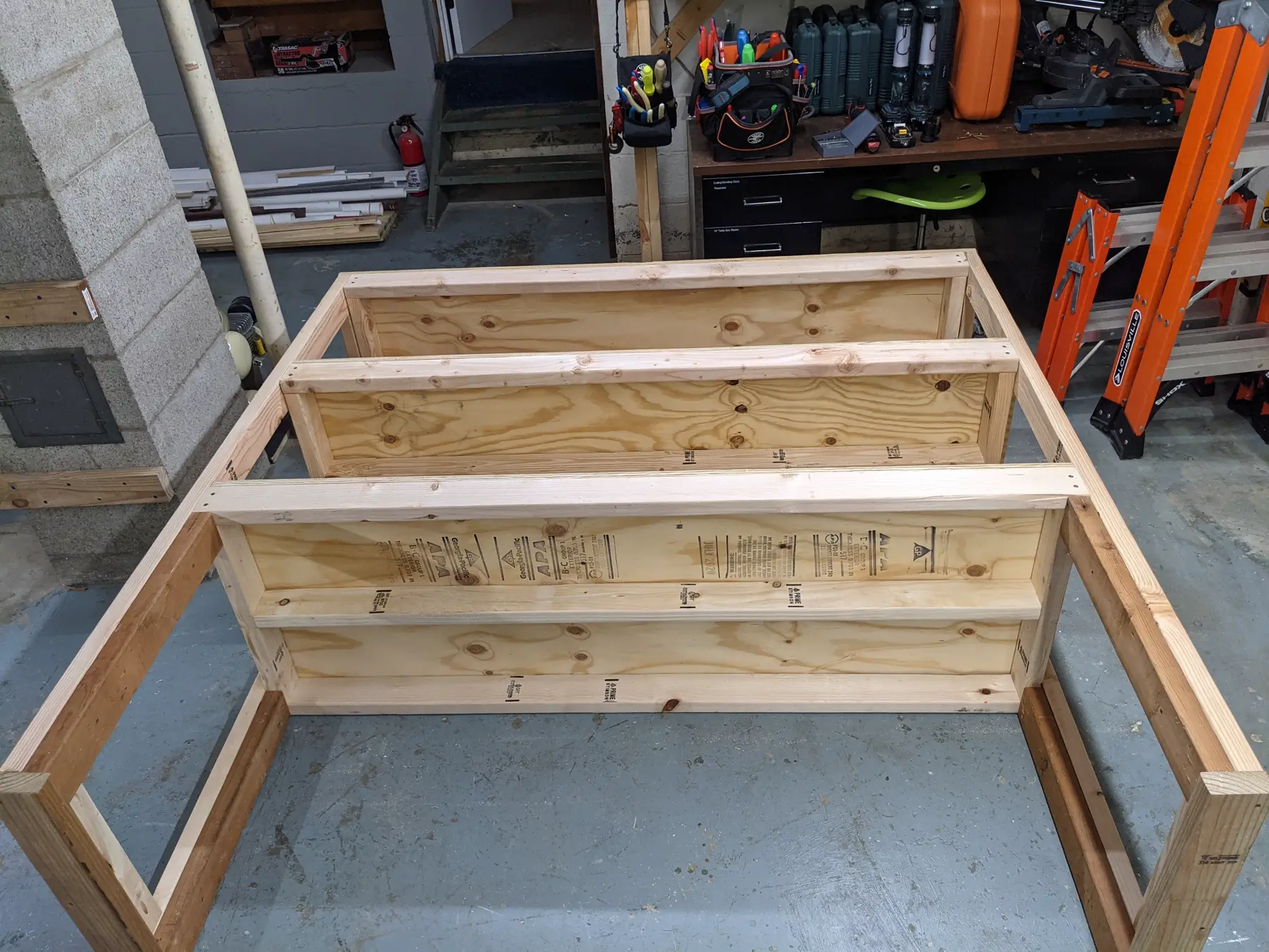 First basement supply shelf assembled as a framed structure on the floor.